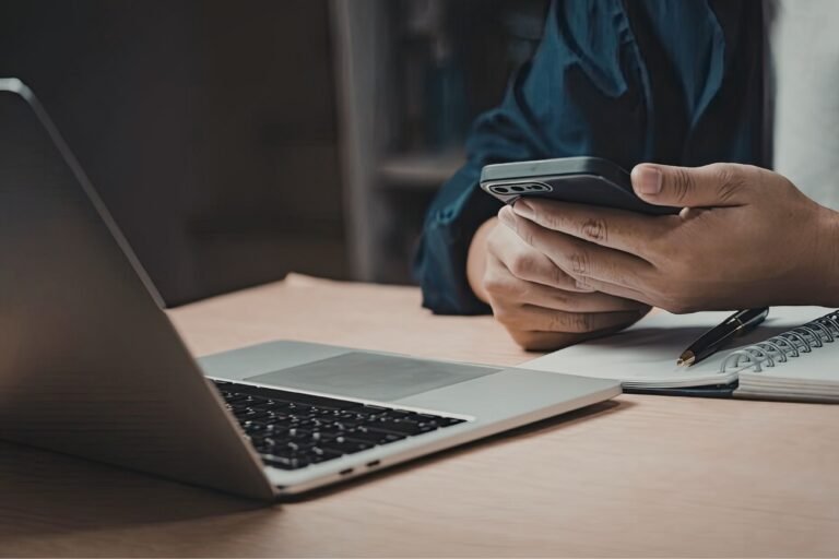 person viewing mobile and laptop devices